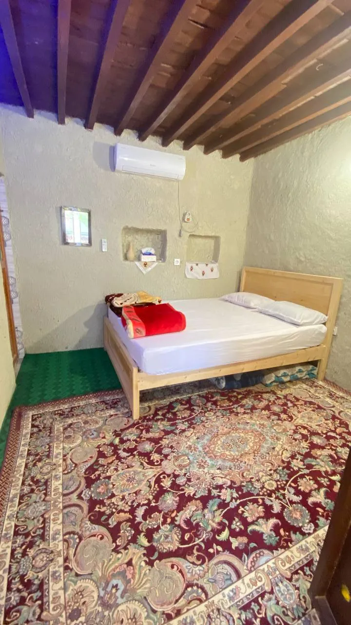 اتاق کاکا با تخت چوبی و فرش سنتی