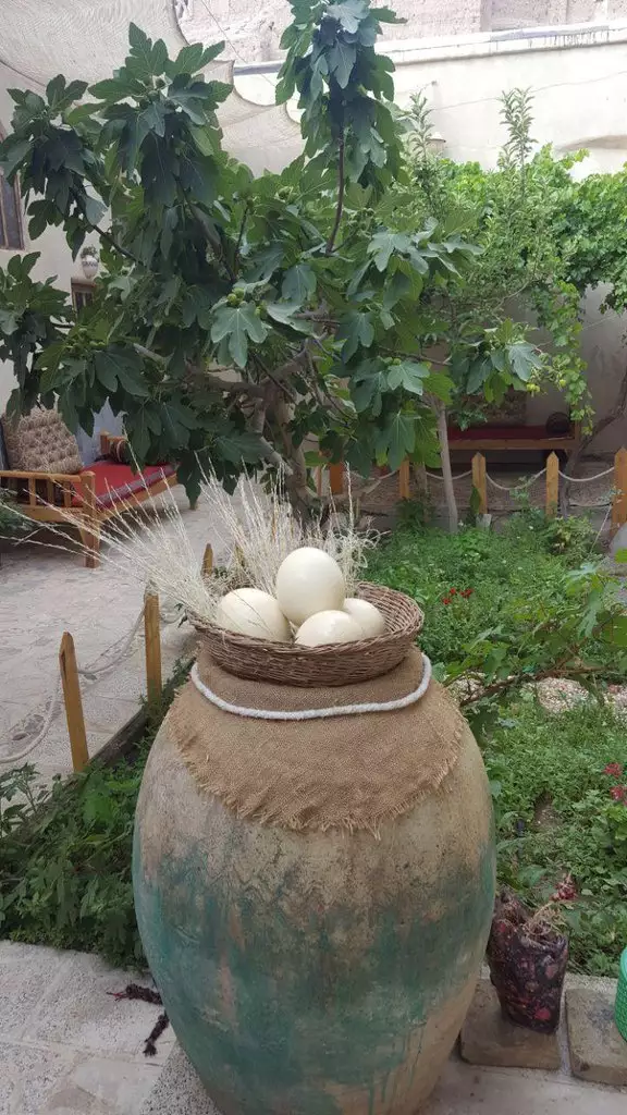 کوزه سفالی و سبد تخم‌مرغ در حیاط هتل خاطره
