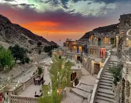 ساختمانهای سنگی هتل بادامشک هنگام غروب