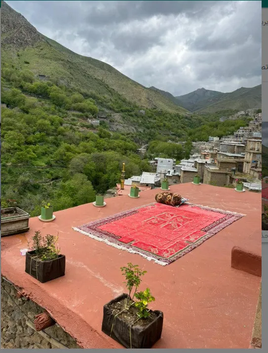پشت‌بام با فرش قرمز و چشم‌انداز کوهستان در تاو