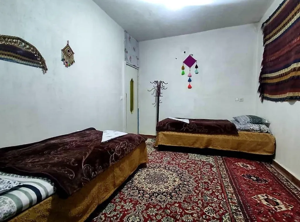 اتاق خانه کورشک با دو تخت و فرشهای دستباف