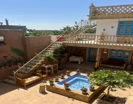 حیاط میراث پدری با حوض آبی و تخت چوبی