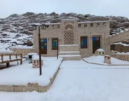 نمای خانه نقلی در میان برف زمستانی