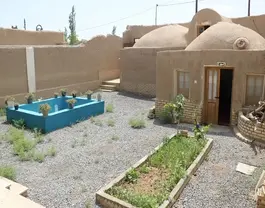 حیاط خانه کله با حوض آبی و باغچه