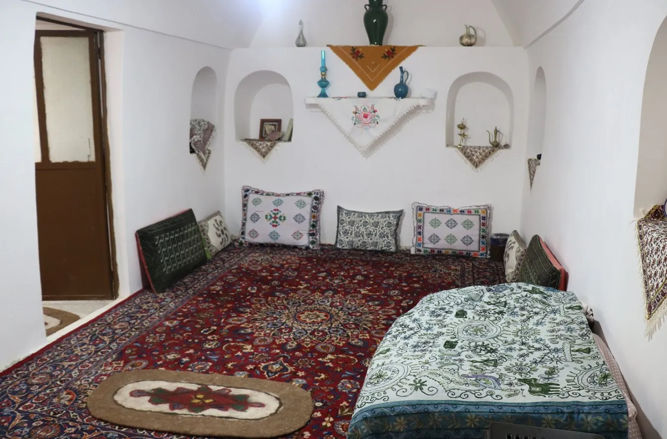 اتاق اقامتگاه خانه کله با فرش قرمز و رختخواب