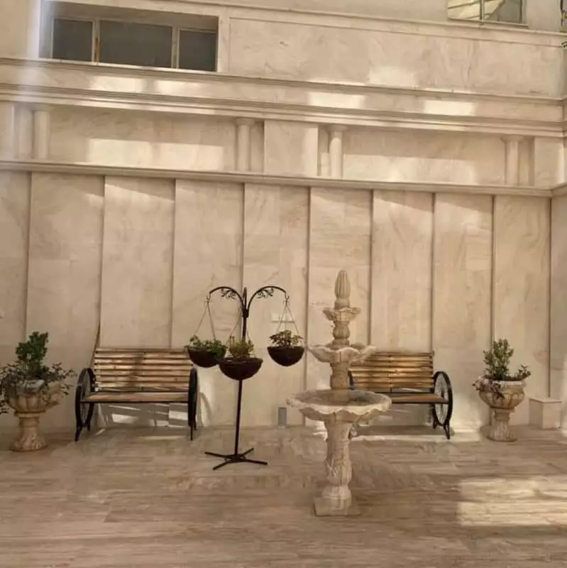 حیاط سنگی هتل مونا با حوض و نیمکت