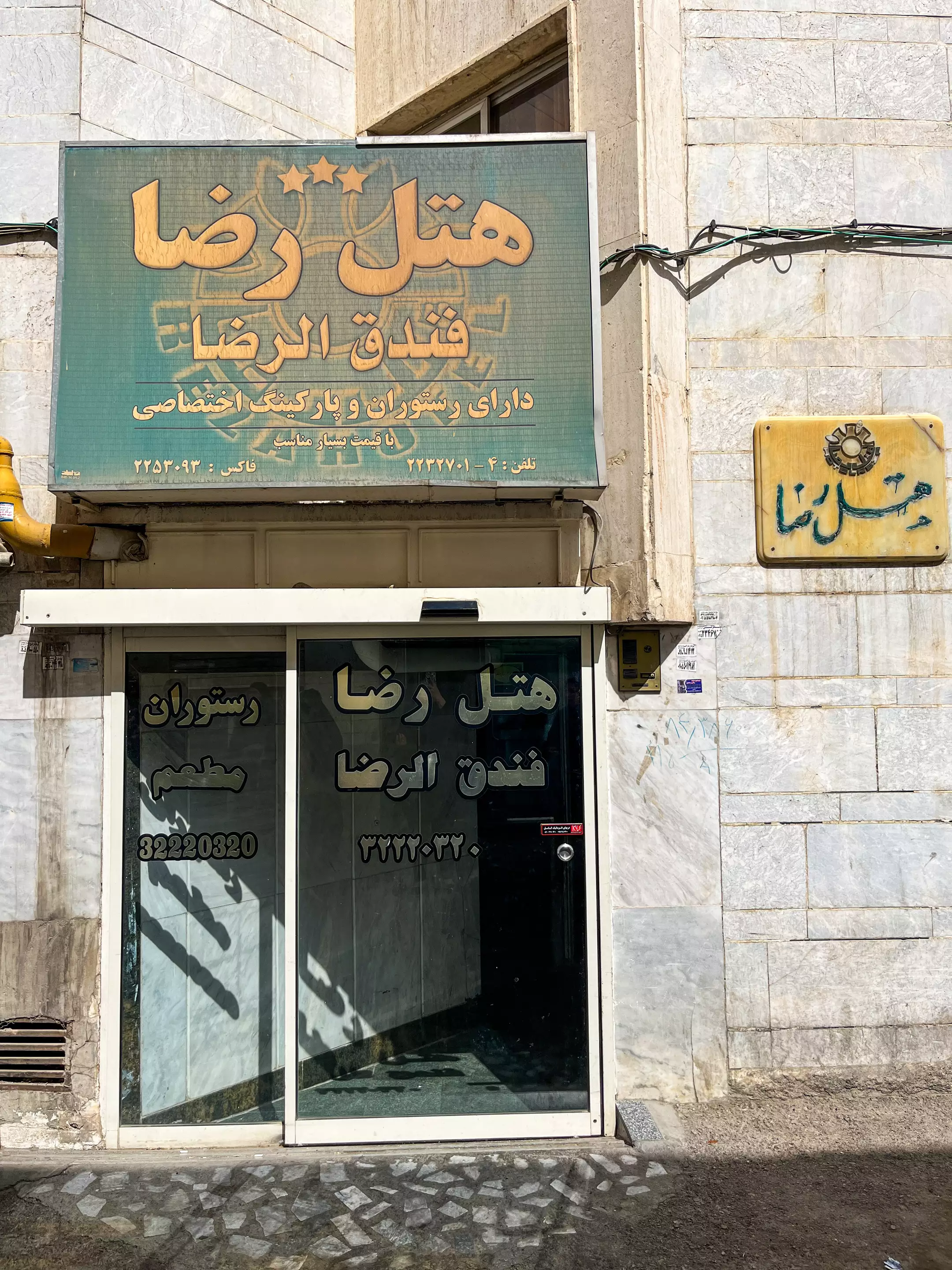 ورودی هتل رضا با تابلوی سردر