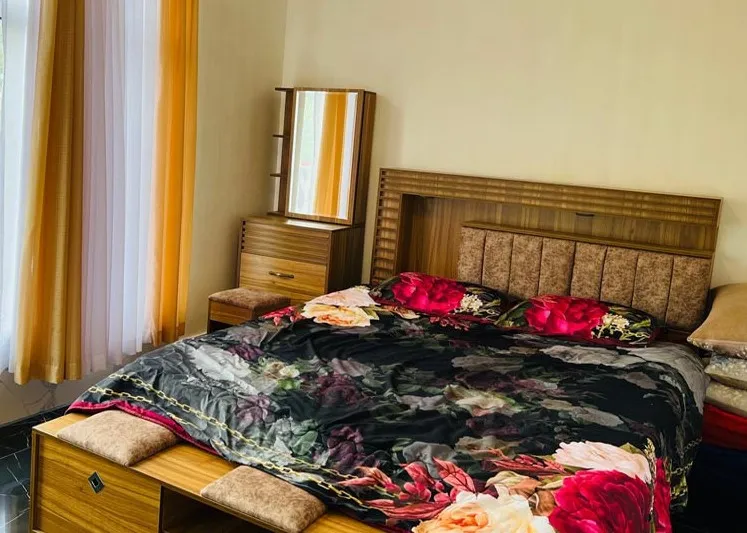 تخت دونفره با روتختی گل‌دار در هتل واران