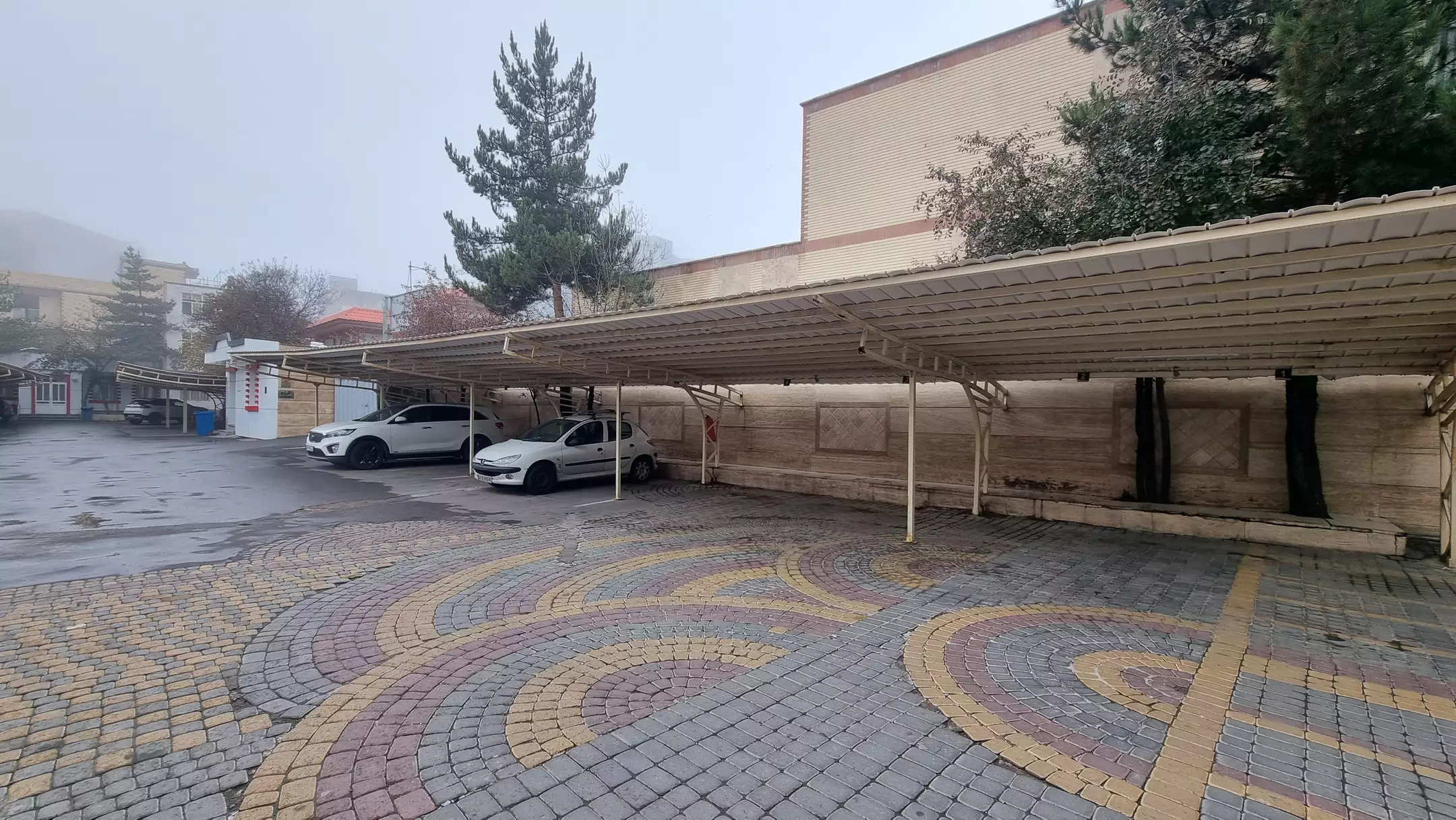 پارکینگ روباز هتل بوستان با سایبان و کف‌پوش سنگی