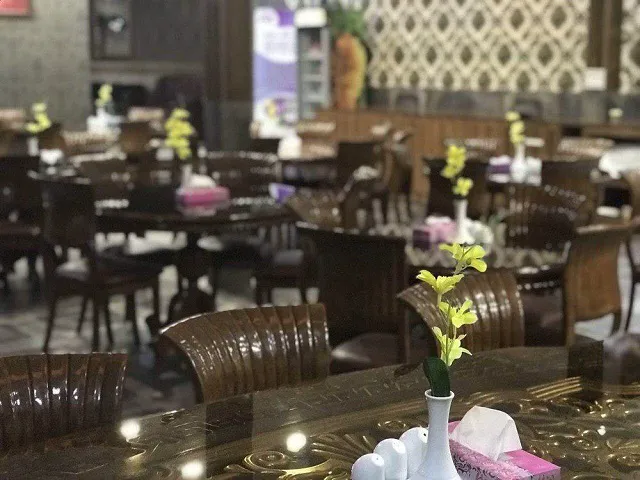 میز رستوران هتل بوستان با گلدان گل زرد