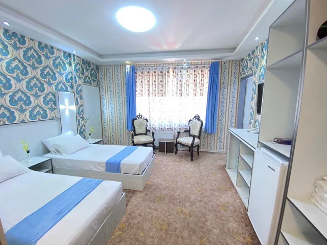 اتاق دو‌تخته هتل بوستان با پنجره و پرده آبی