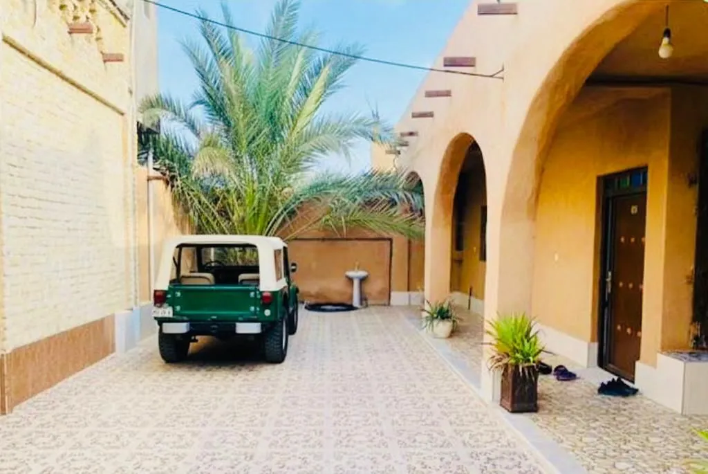 حیاط آفتاب جنوب با خودرو و درختان نخل