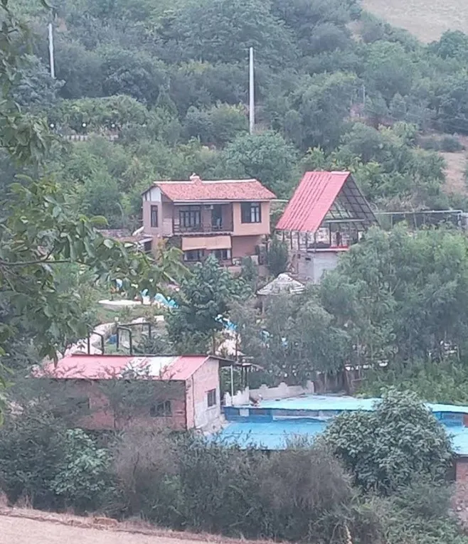 ساختمان‌های گل باغ باران در میان درختان