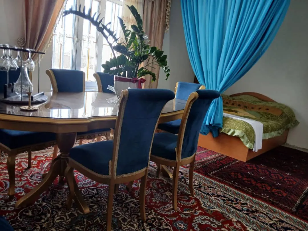 میز ناهارخوری و تخت در اتاق هتل آریان