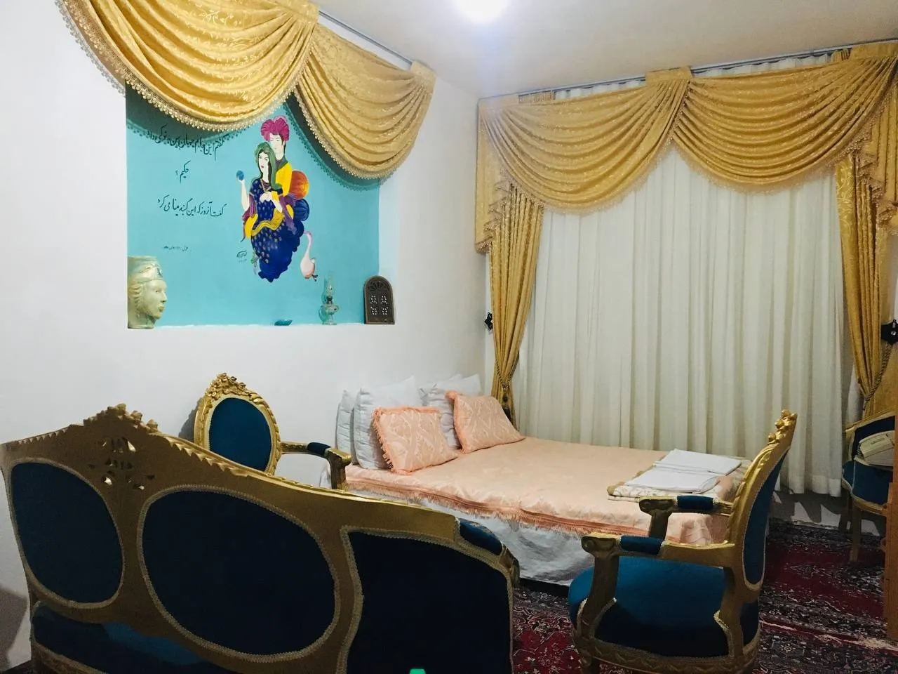 اتاق هتل آریان با تخت دونفره و پرده‌های طلایی