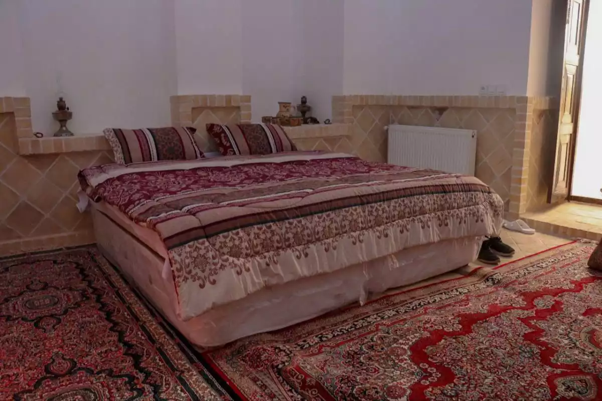 تخت دونفره با روتختی طرح‌دار هتل شاخه نبات