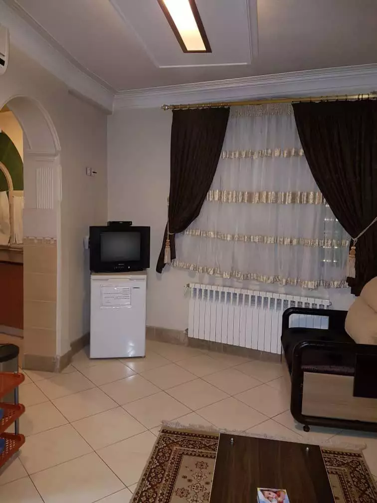 نشیمن ویلا با تلویزیون، پنجره و مبل