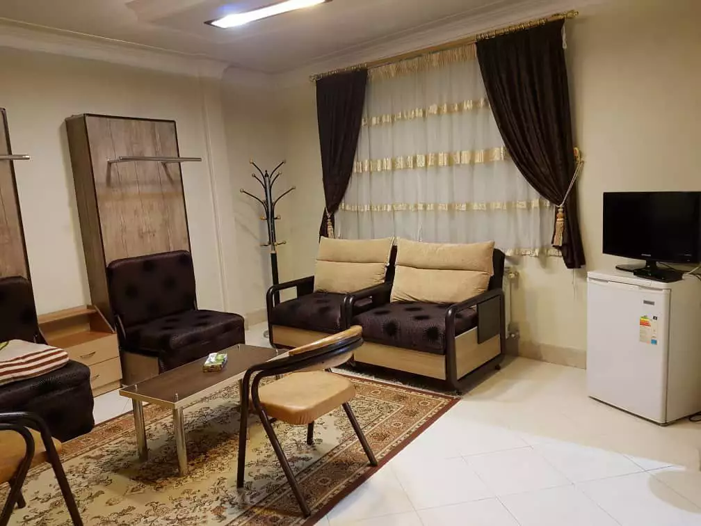 نشیمن اتاق با تلویزیون و مبلمان در ویلا