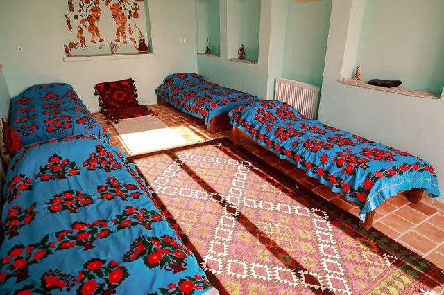 سه تخت با روتختی گل‌دار در خانه عروسک
