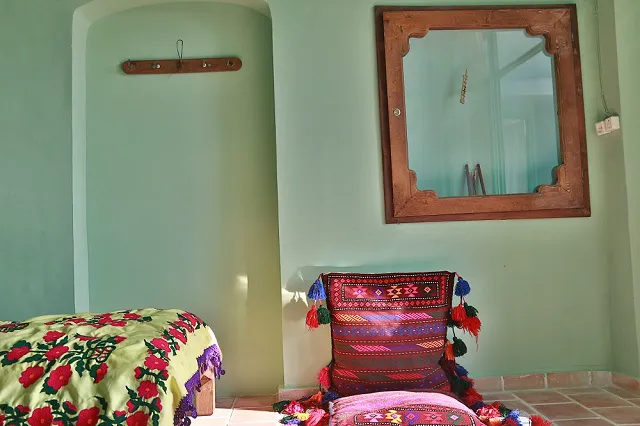 تخت گل‌دار و پشتی سنتی در خانه عروسک