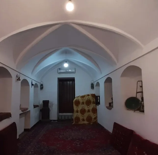 فضای نشیمن رویای کویر با سقف طاق‌دار و فرش ایرانی