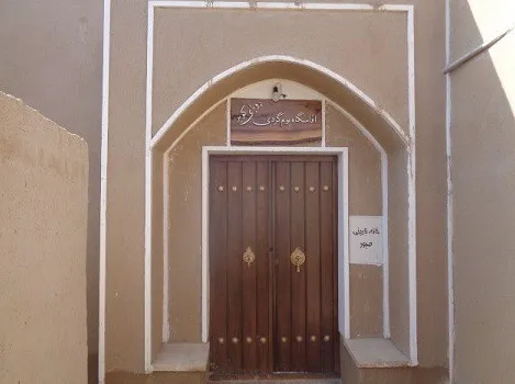 ورودی هتل رویای کویر با سردر قوسی و در چوبی