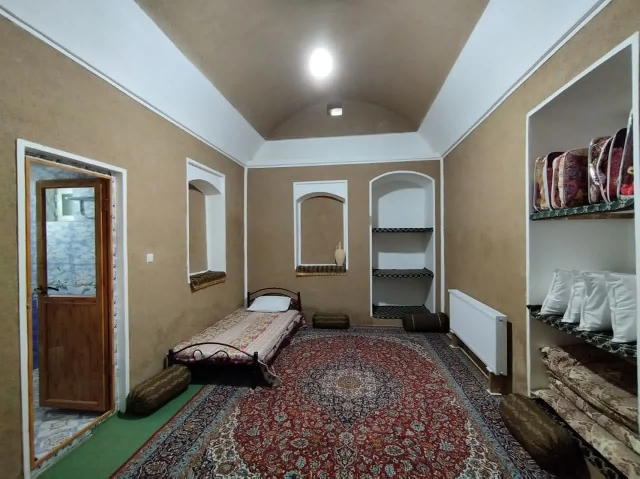 اتاق اقامتگاه عمارت شاباز با فرش قرمز و تخت زمینی