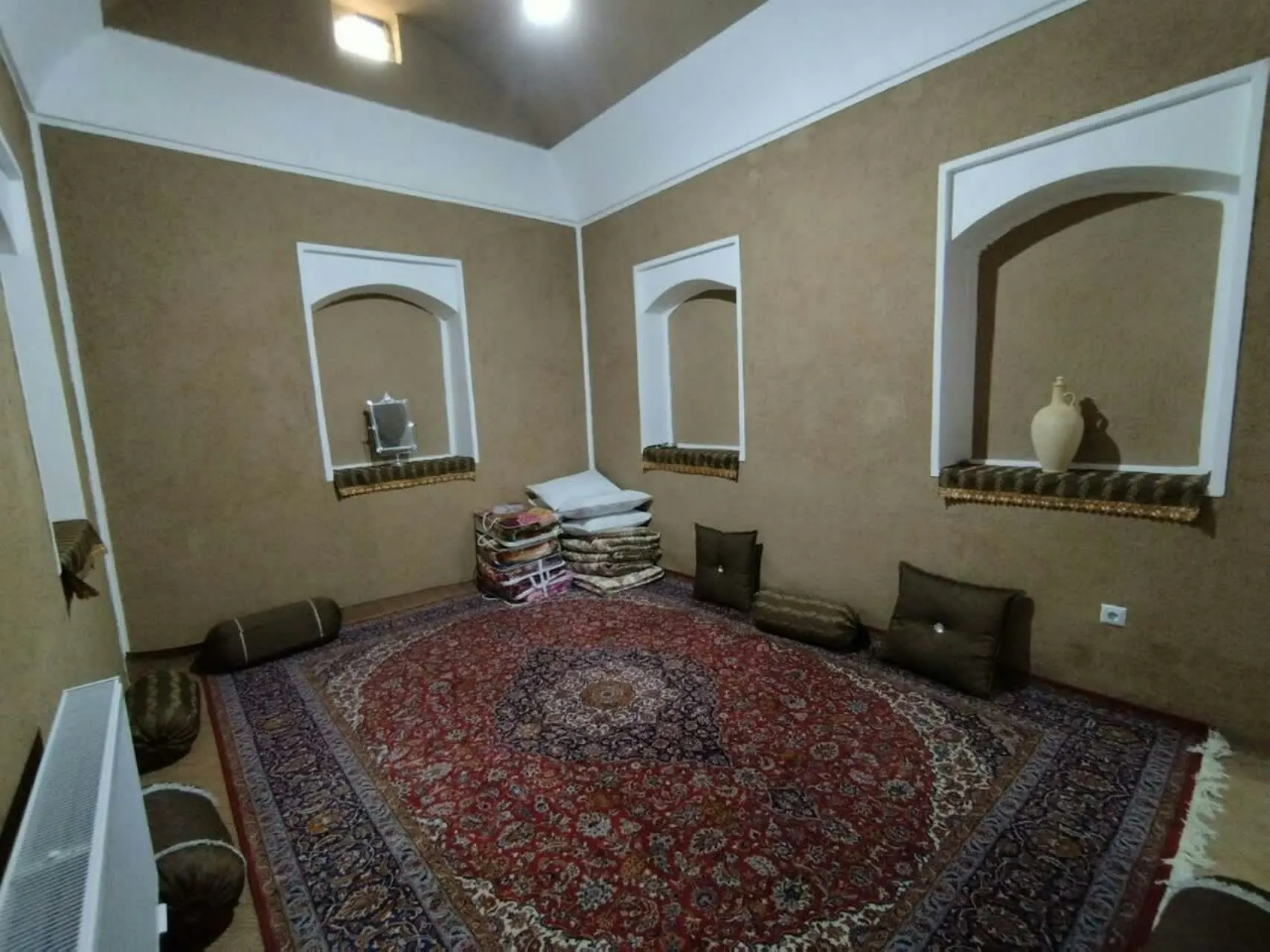 اتاق نشیمن عمارت شاباز با فرش دستباف و پشتی