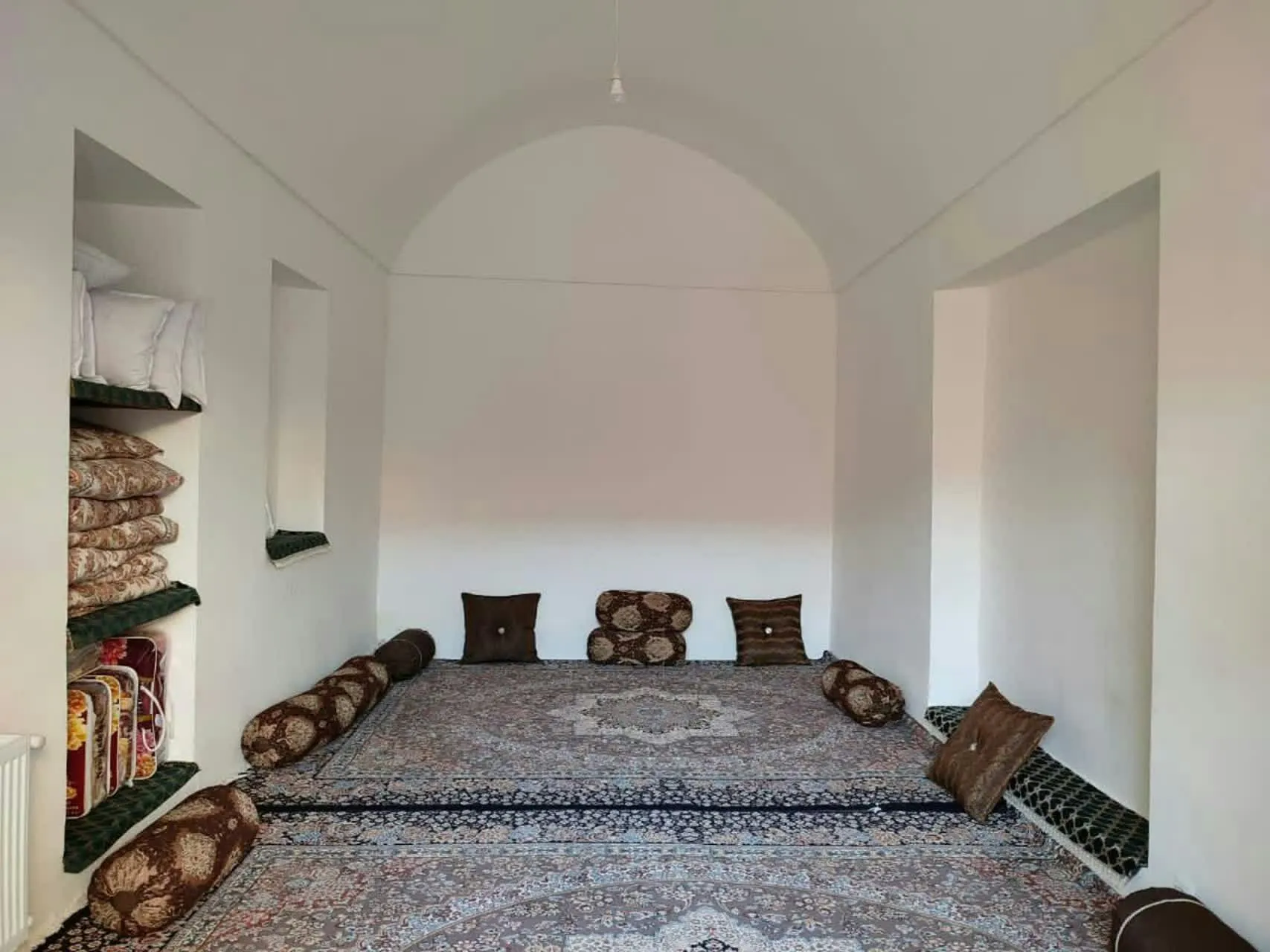 اتاق طاقدار عمارت شاباز با فرش و پشتیهای زمینی