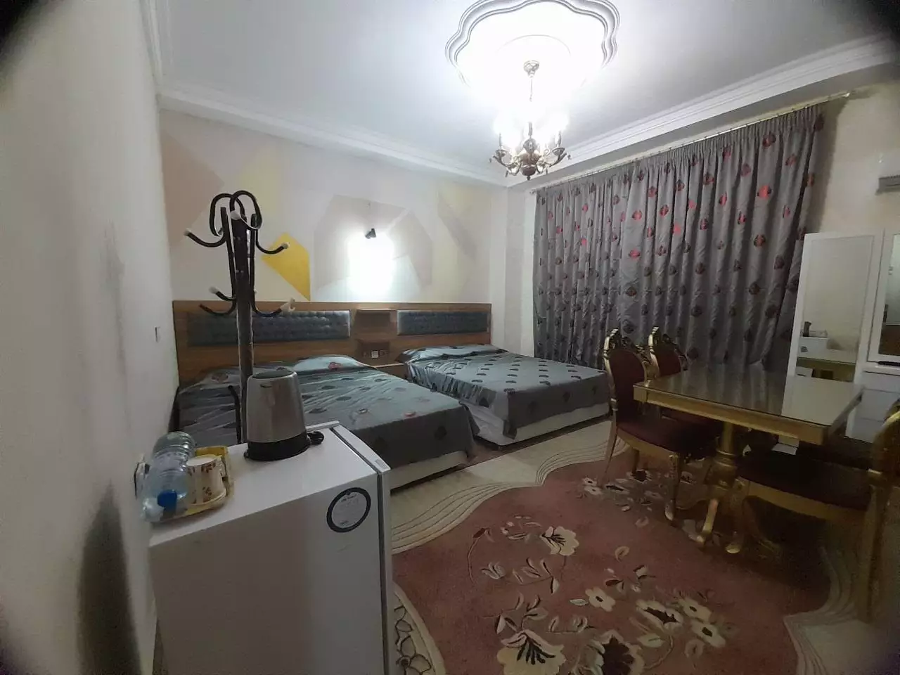 اتاق احمد با دو تخت و میز غذاخوری