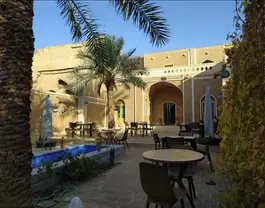 حیاط عمارت شاطر با حوض و میزهای فضای باز