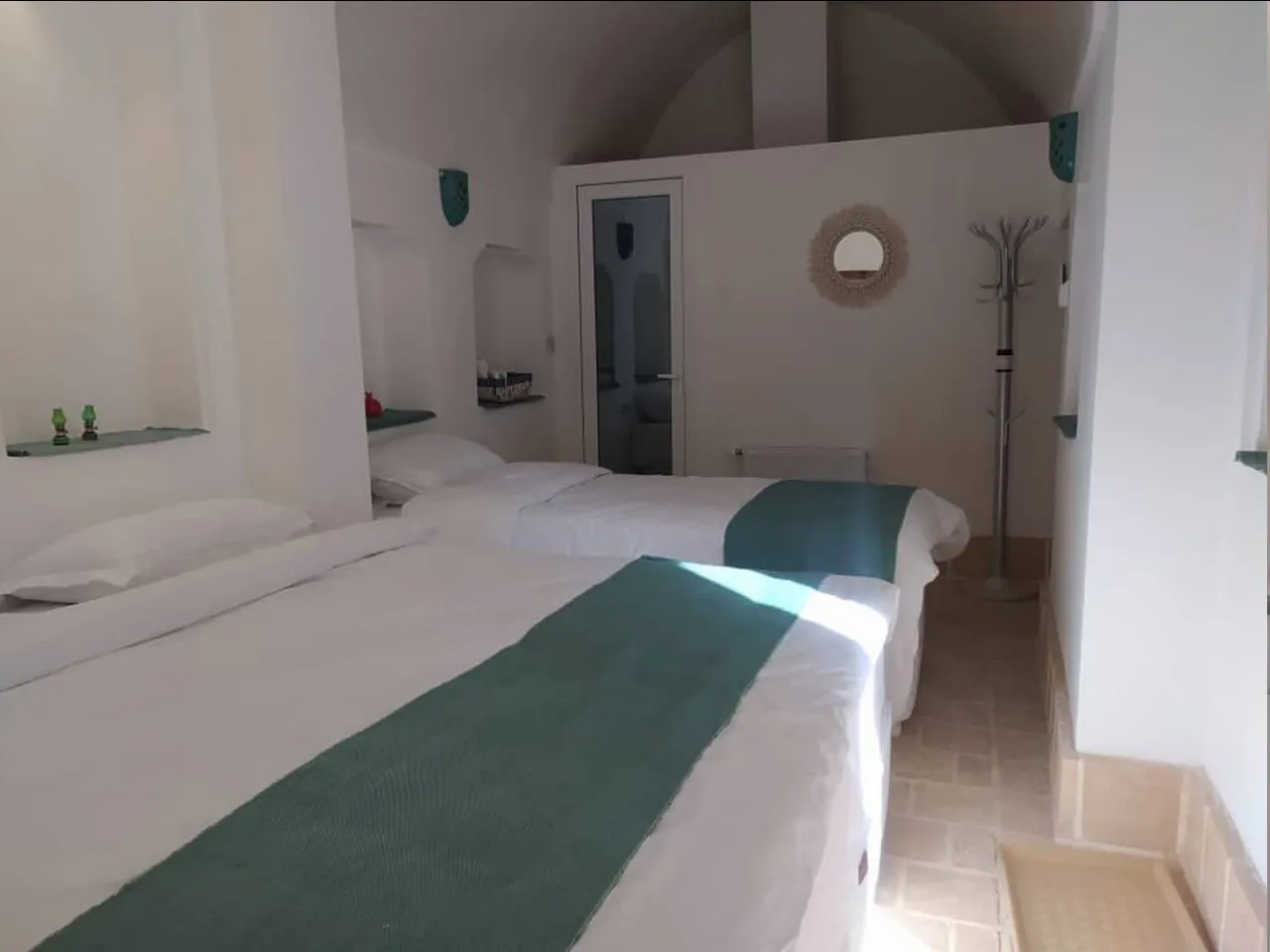 تخت‌های اتاق عمارت شاطر با روتختی سبز