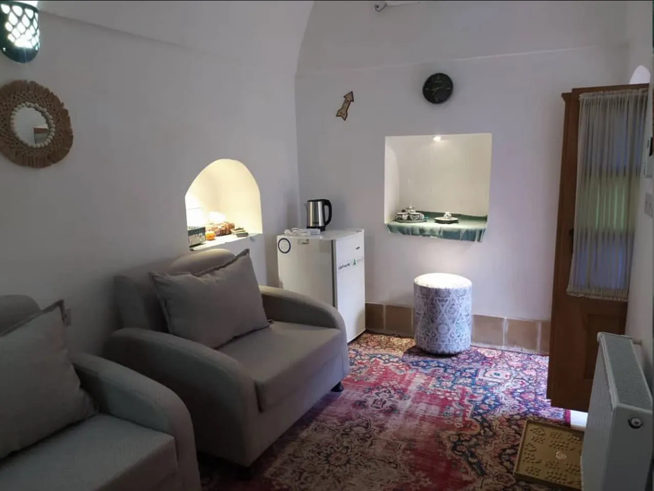 نشیمن عمارت شاطر با مبل خاکستری و فرش ایرانی