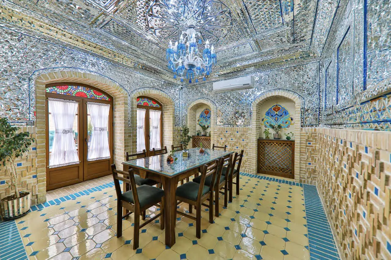 اتاق غذاخوری هتل جیران با آینه‌کاری و میز چوبی
