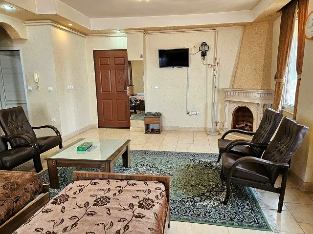 نشیمن اتاق ایساتیس با تلویزیون و شومینه