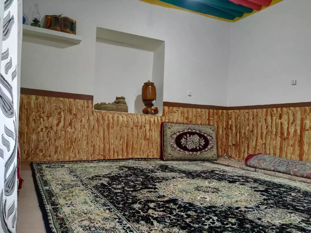 فضای نشیمن سنار با فرش ایرانی و دیوارپوش چوبی