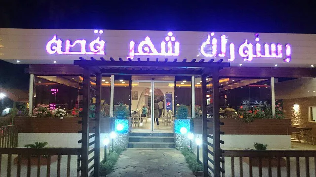 ورودی رستوران شهر قصه با تابلوی نورانی شبانه