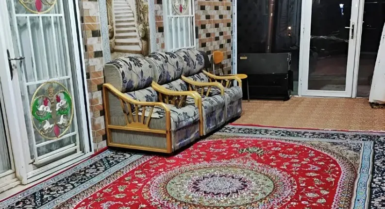 برج بهشت؛ فضای نشیمن با مبل و فرش قرمز