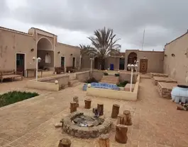 حیاط اقامتگاه بابا حاجی حلوان با آتشدان و نخل