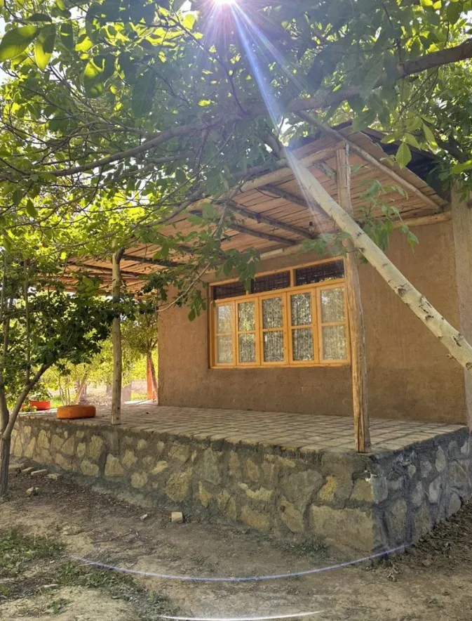 کلبه گِلی در میان درختان اقامتگاه دره خورشید