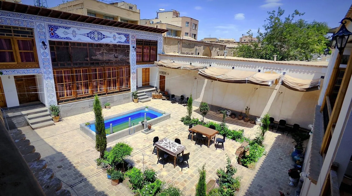 حیاط عمارت تاریخی دلگشا با حوض و فضای نشیمن