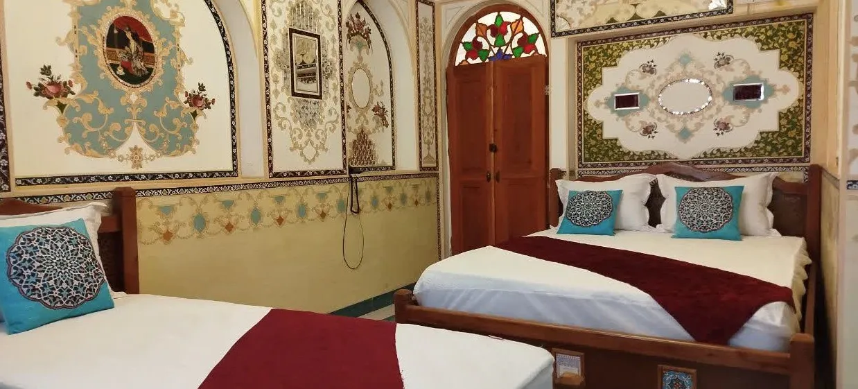 دو تخت چوبی در اتاق تزیین‌شده هتل حیدرمیرزا