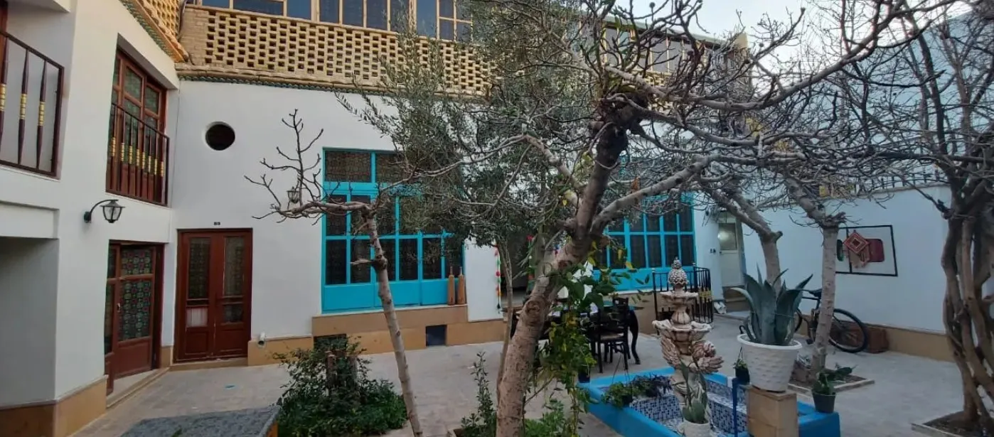 حیاط اقامتگاه طاها و مهسان با حوض و درختان