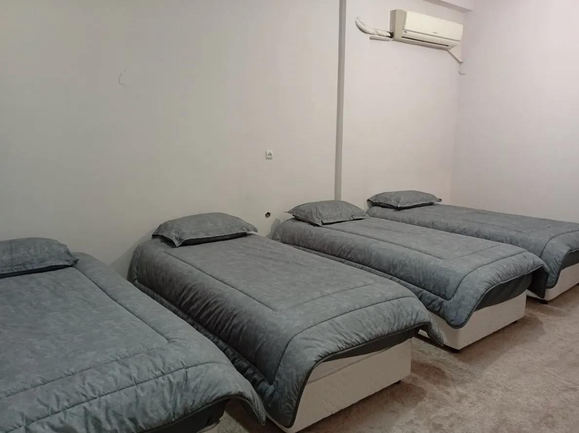 سه تخت یکنفره با روتختی خاکستری در هتل فرهیختگان