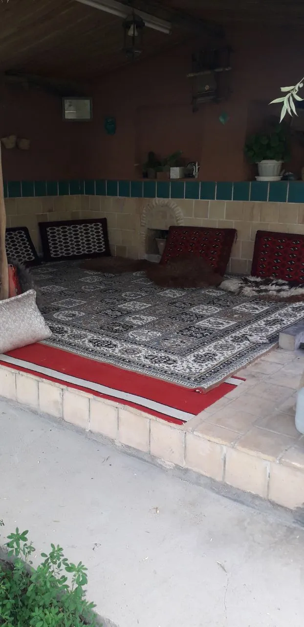 فضای نشیمن سنتی آنایوردم بلداجی با فرش و پشتی