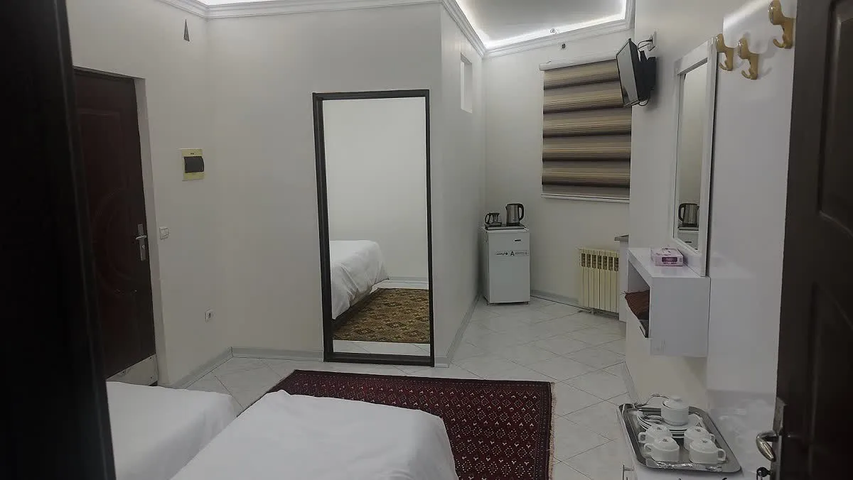 آینه قدی و تخت اتاق هتل وحیدیان