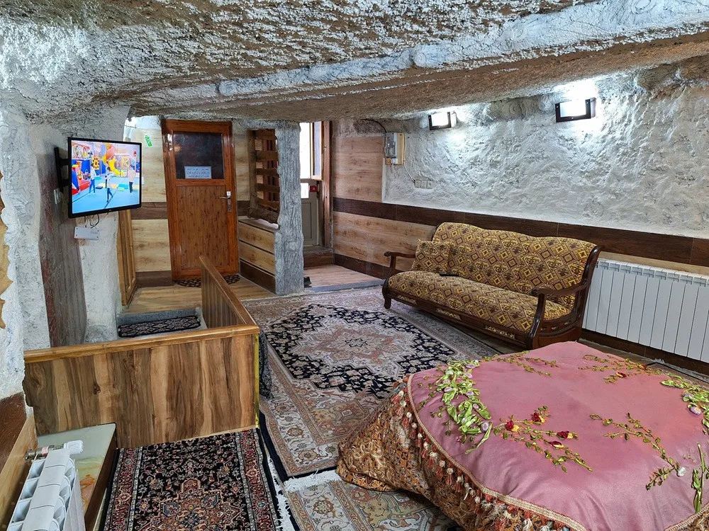 نشیمن عمارت سنگی با تلویزیون و مبل طرحدار