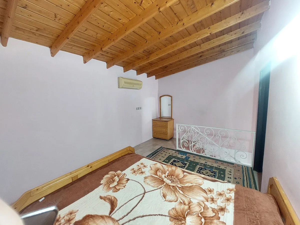 تخت گل‌دار در اتاق پارادایس با سقف چوبی