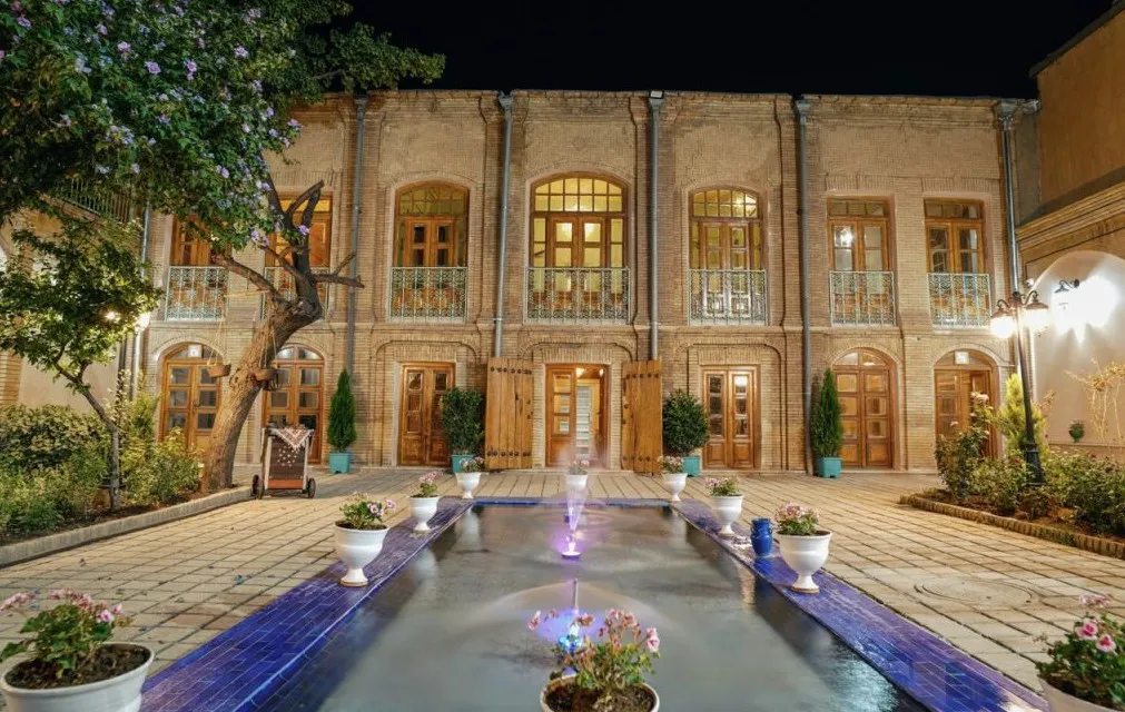 حیاط شبانه هتل آوا با حوض و نمای آجری