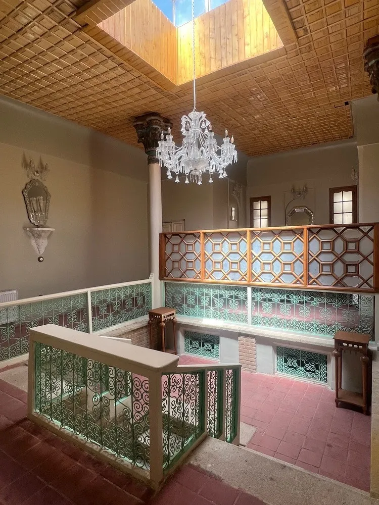 نیم‌طبقه با نرده‌های تزئینی و لوستر در هتل آوا